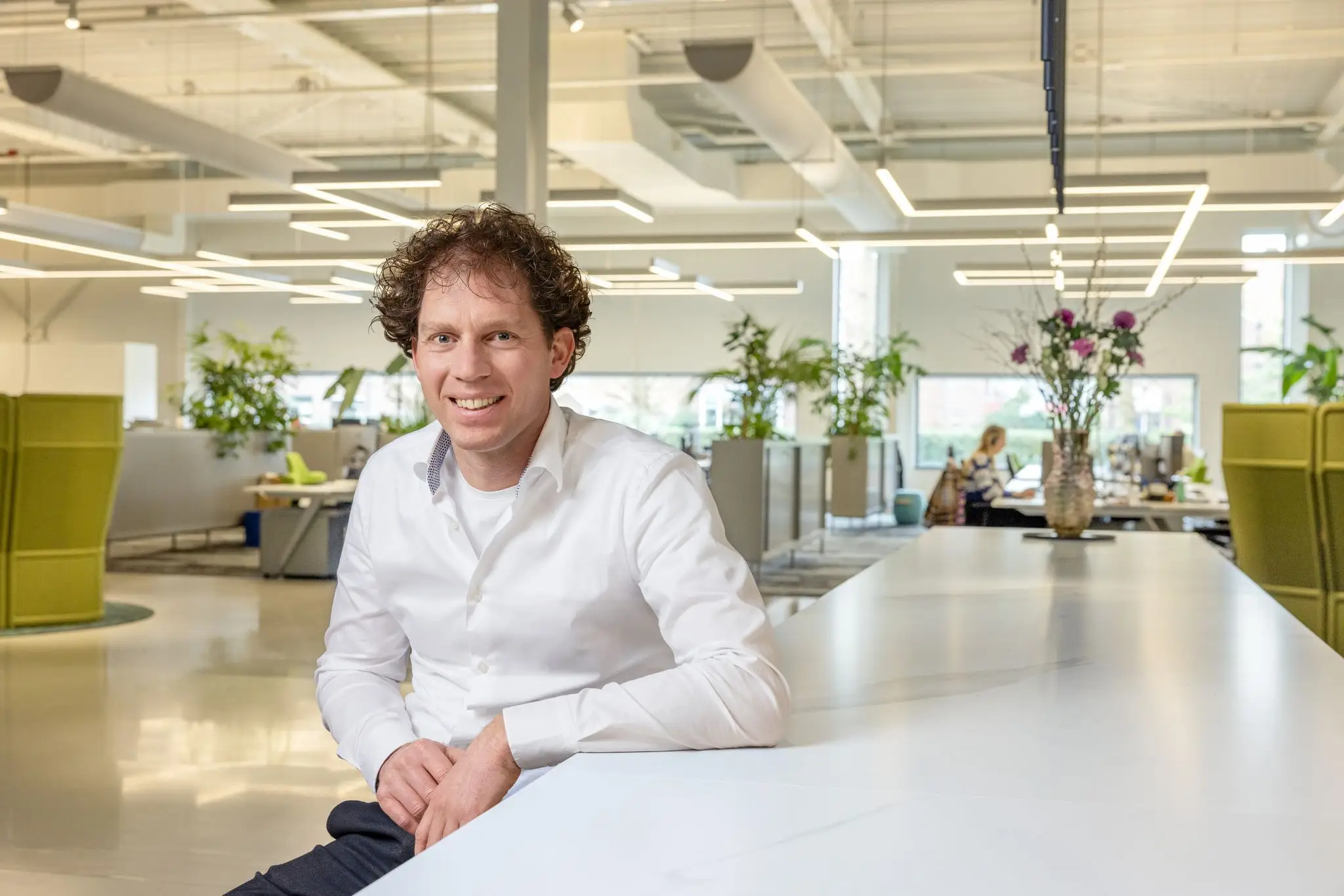 Jeroen Oostewechel zittend aan lange witte tafel
