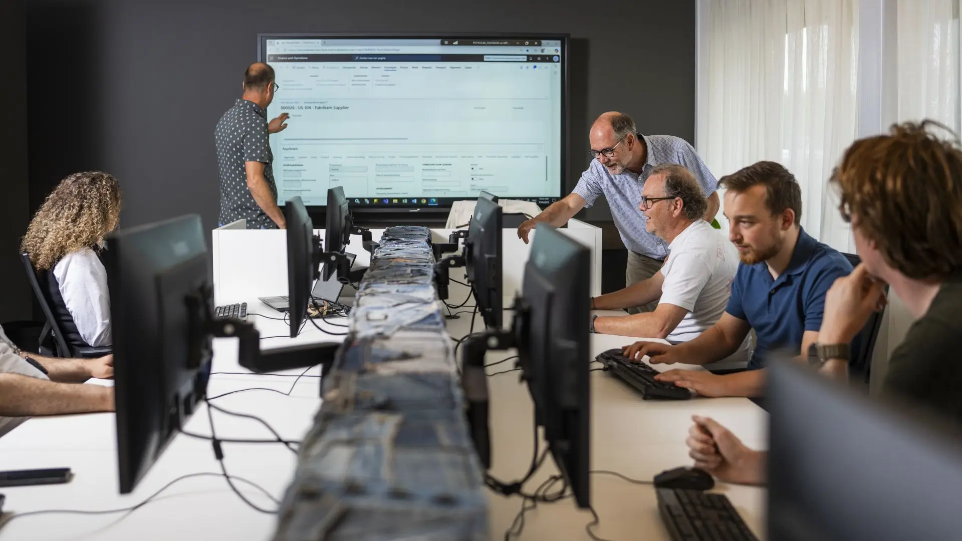 Een groep cursisten die uitleg krijgen van een trainer