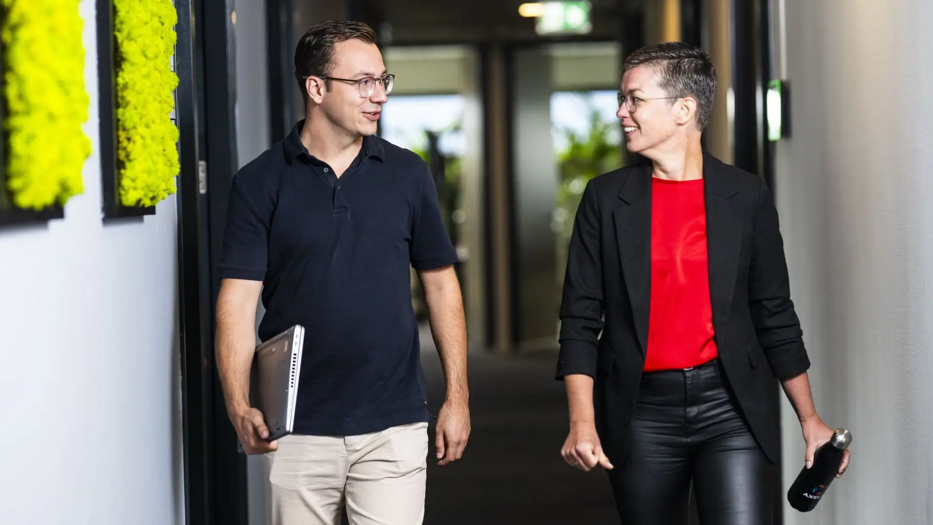 Twee medewerkers van Axelio lopend door de gang