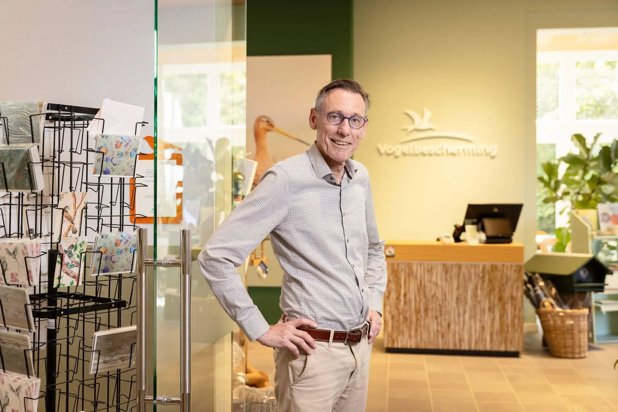  René Roskamp van de Vogelbescherming staand voor het logo