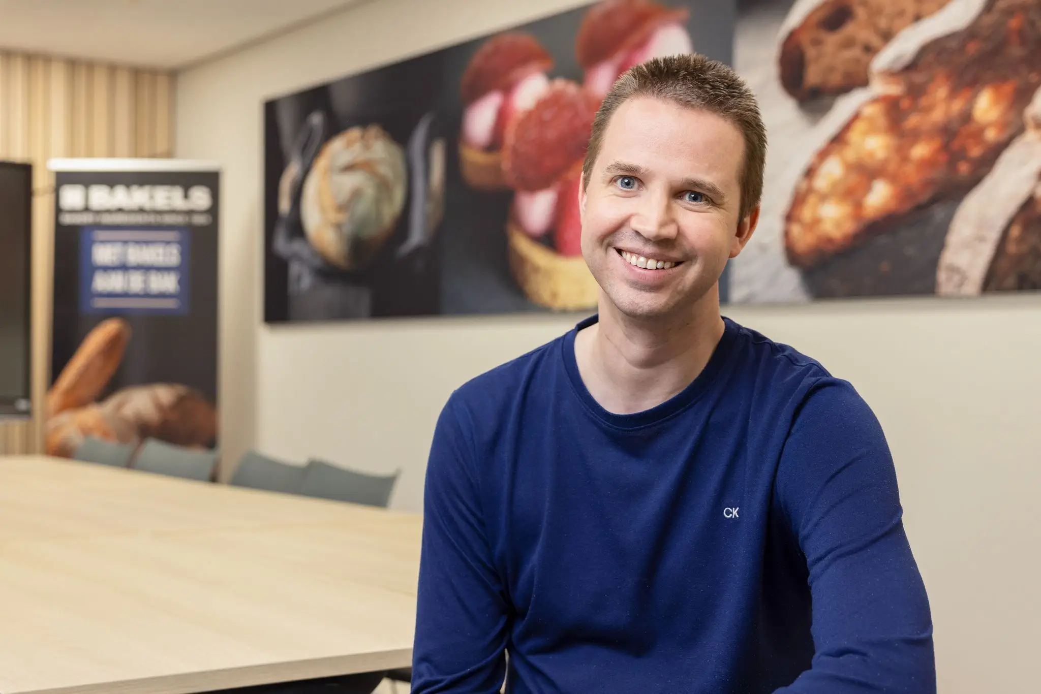 Nicky Gommers van Bakels lachend aan een vergadertafel