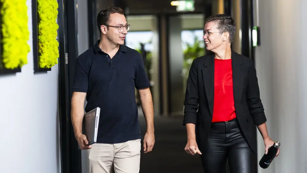 Twee medewerkers van Axelio lopend door de gang