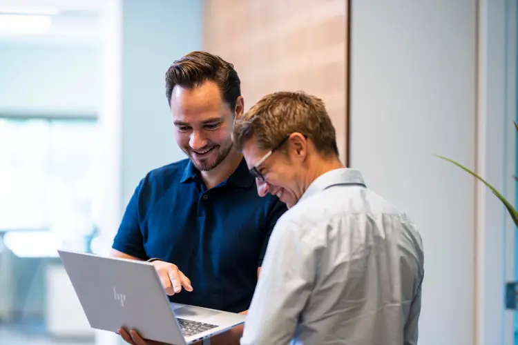 2 lachende mannen, kijkend naar een laptopscherm