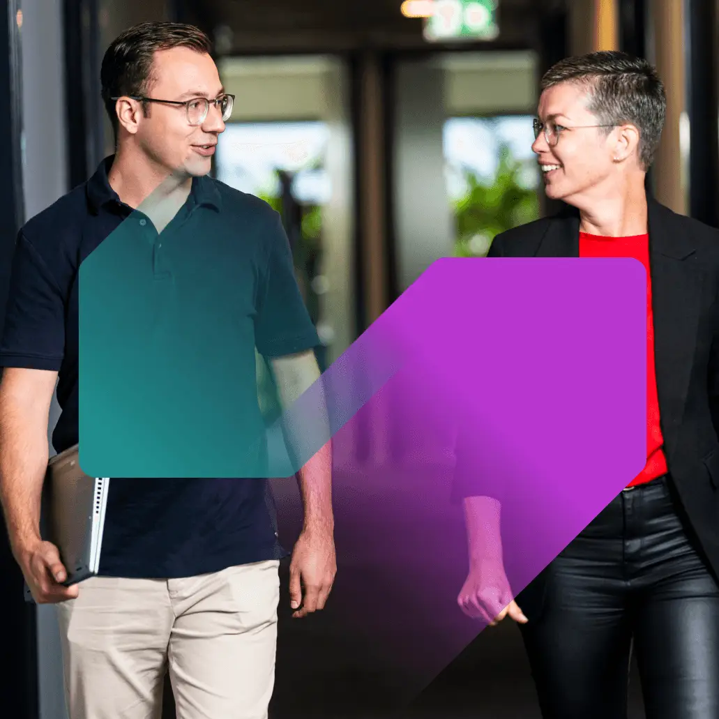 Een man en een vrouw die elke vriendelijk aankijken lopend door de gang