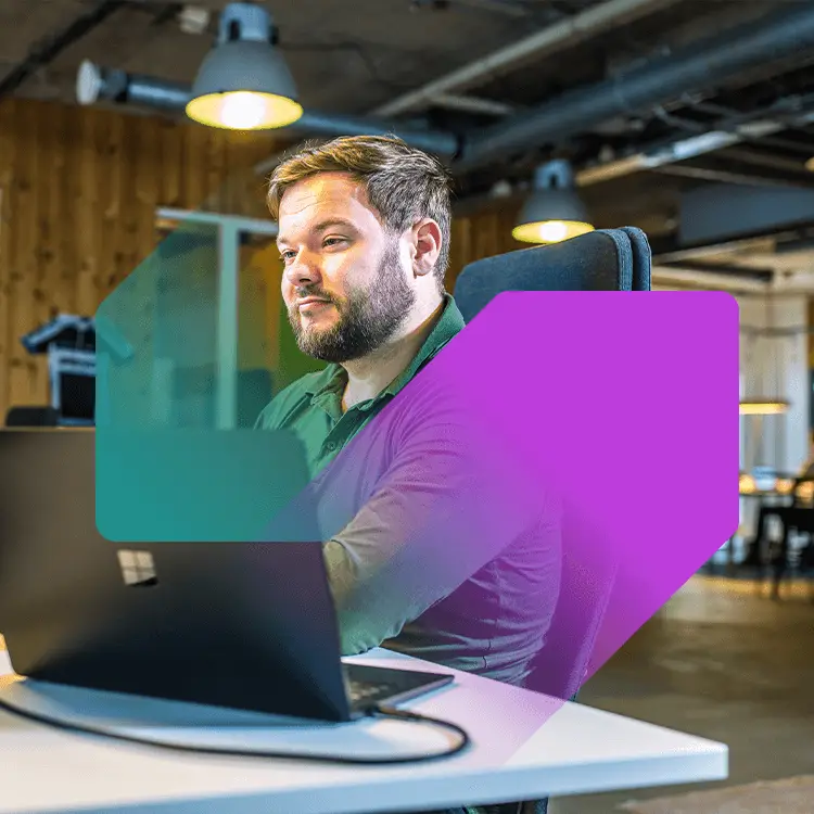 Werkende man achter een bureau en kijkend naar computerscherm